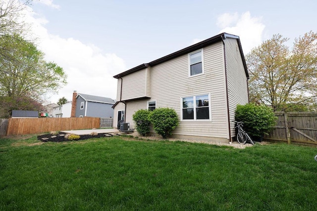 back of property featuring a lawn, a fenced backyard, and central air condition unit