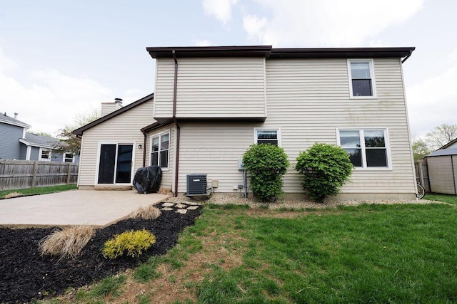 rear view of property featuring a yard, a patio, fence, and central AC unit