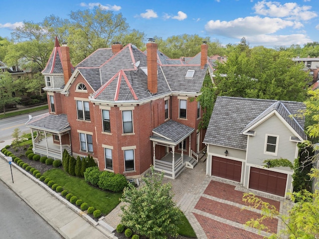 884 Neil Ave, Columbus, OH 43215 - view of front of house with a chimney, an attached garage, brick siding, and driveway