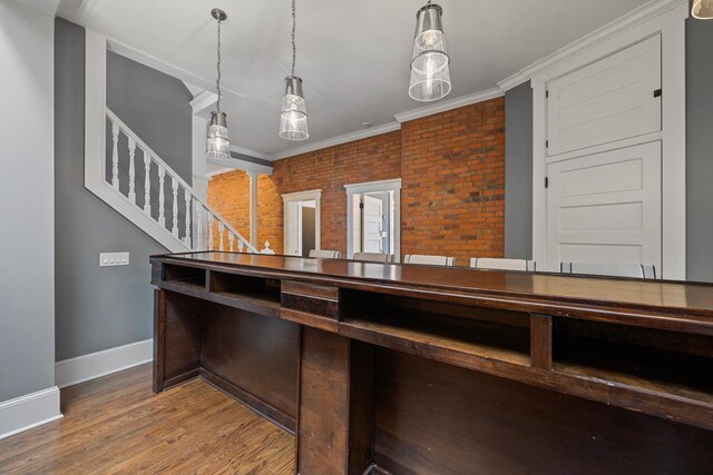 884 Neil Ave, Columbus, OH 43215 - kitchen with wood finished floors, brick wall, pendant lighting, and crown molding