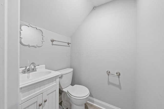 884 Neil Ave, Columbus, OH 43215 - half bathroom featuring lofted ceiling, vanity, and wood finished floors