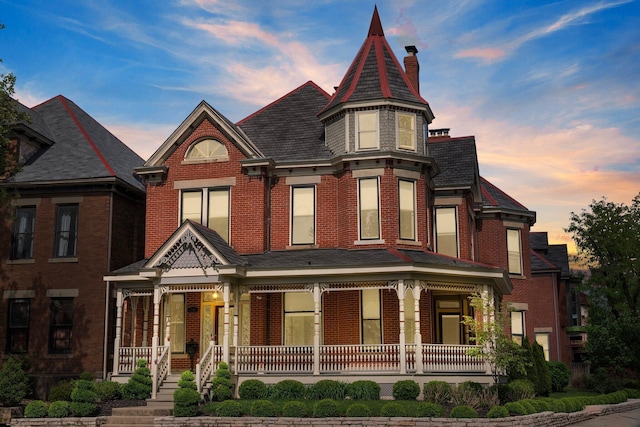 884 Neil Ave, Columbus, OH 43215 - victorian home featuring a porch, a chimney, and brick siding