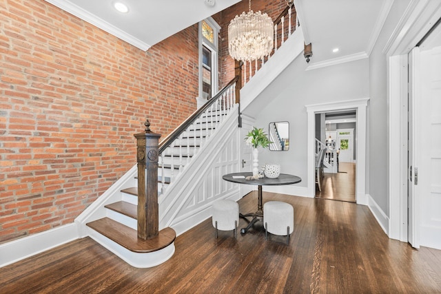 884 Neil Ave, Columbus, OH 43215 - stairs with wood finished floors, a chandelier, brick wall, recessed lighting, and ornamental molding