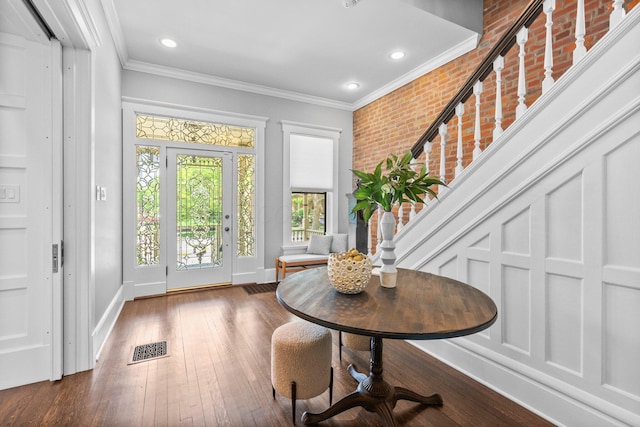 884 Neil Ave, Columbus, OH 43215 - entryway featuring crown molding, stairway, dark wood finished floors, brick wall, and recessed lighting
