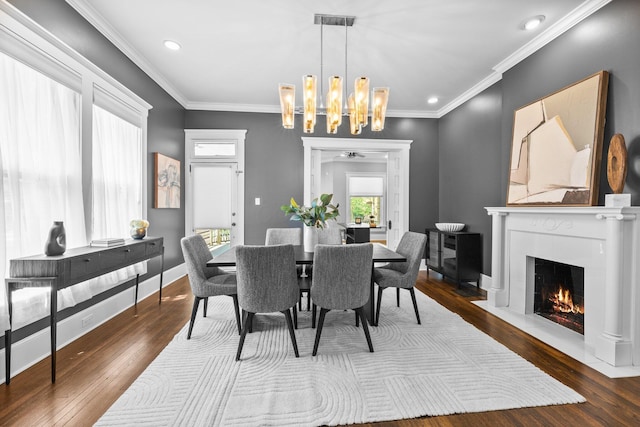884 Neil Ave, Columbus, OH 43215 - dining room with a chandelier, dark wood-type flooring, a fireplace with flush hearth, recessed lighting, and crown molding