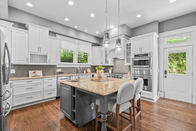 884 Neil Ave, Columbus, OH 43215 - kitchen with a warming drawer, white cabinets, a center island with sink, stainless steel appliances, and recessed lighting