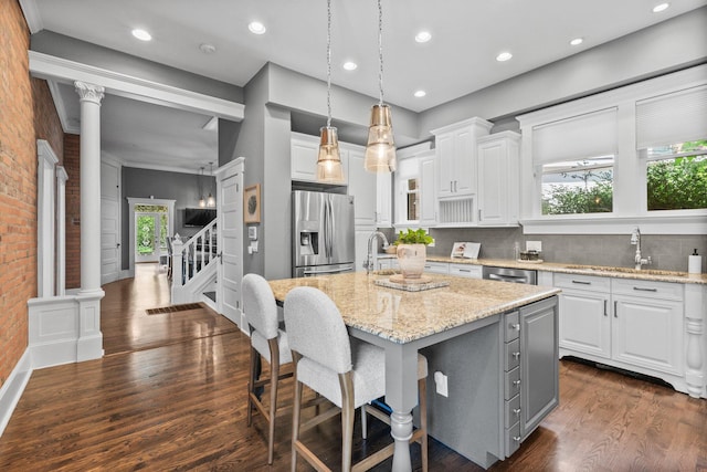 884 Neil Ave, Columbus, OH 43215 - kitchen featuring stainless steel appliances, white cabinets, an island with sink, dark wood-type flooring, and light stone countertops
