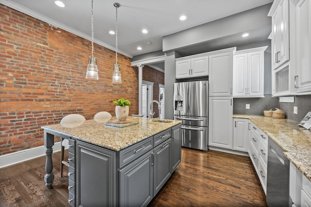 884 Neil Ave, Columbus, OH 43215 - kitchen with stainless steel appliances, gray cabinets, white cabinetry, a center island with sink, and brick wall