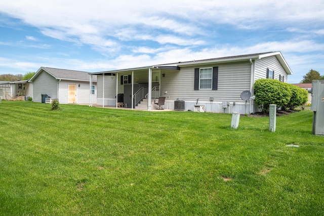 view of front of property featuring central air condition unit, entry steps, and a front lawn