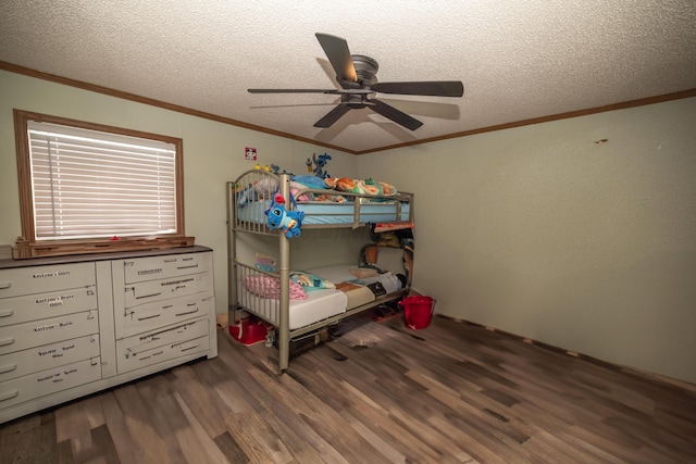 bedroom with ornamental molding, a textured ceiling, a ceiling fan, and wood finished floors