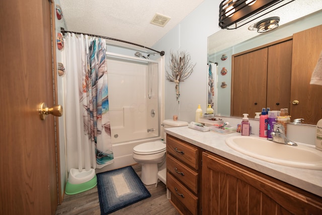 full bathroom with visible vents, wood finished floors, shower / tub combo, vanity, and toilet