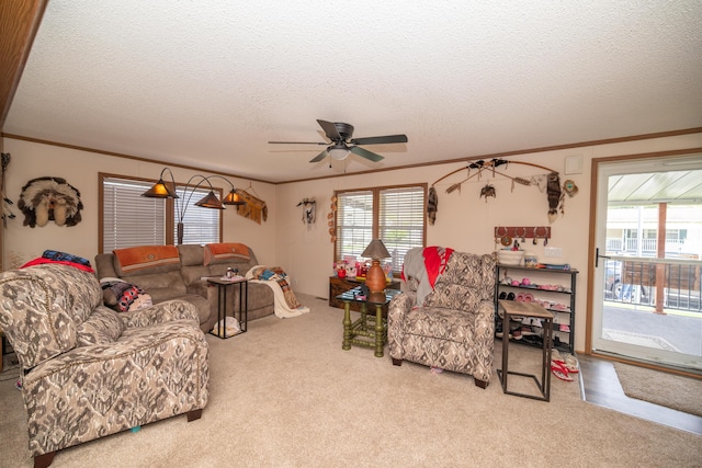 carpeted living room featuring crown molding, a ceiling fan, a textured ceiling, and a wealth of natural light