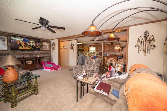 carpeted living room with a textured ceiling, ceiling fan, and ornamental molding