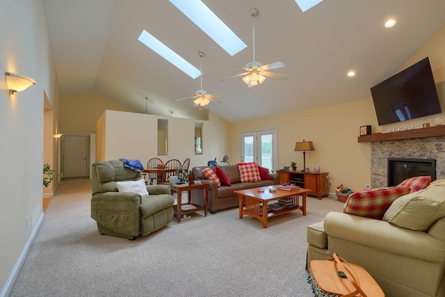 4656 Meadowgrove Dr NW, Carroll, OH 43112 - living area featuring light carpet, a skylight, ceiling fan, a stone fireplace, and high vaulted ceiling