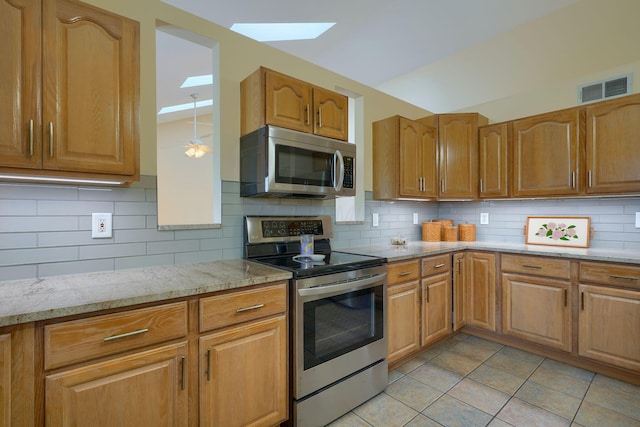 4656 Meadowgrove Dr NW, Carroll, OH 43112 - kitchen with appliances with stainless steel finishes, a skylight, light stone countertops, and decorative backsplash
