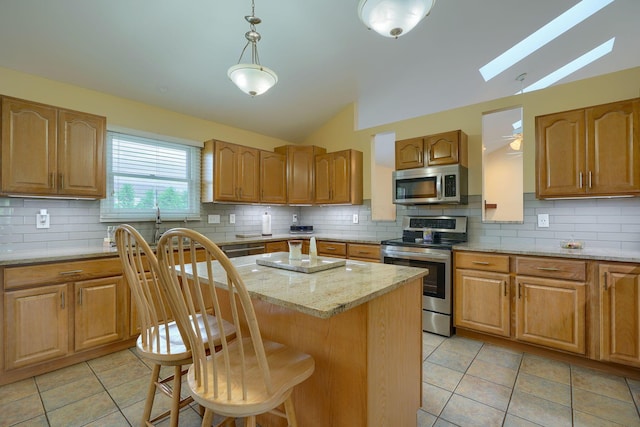 4656 Meadowgrove Dr NW, Carroll, OH 43112 - kitchen with stainless steel appliances, lofted ceiling, a skylight, a kitchen island, and a kitchen bar