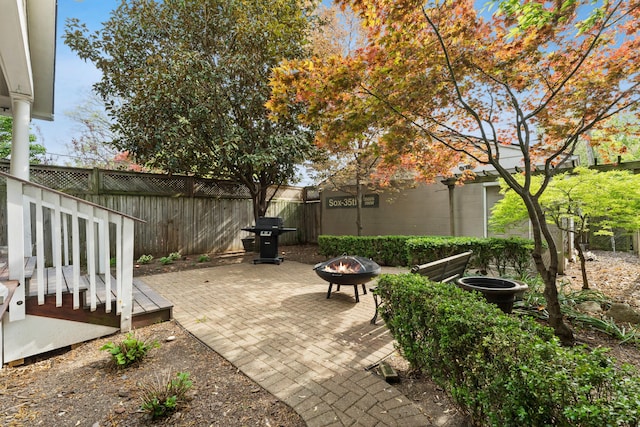 view of patio / terrace featuring a grill, fence, and an outdoor fire pit
