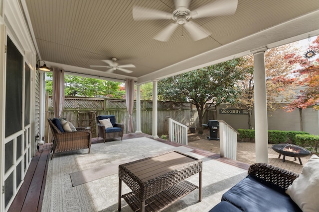 view of patio / terrace featuring ceiling fan, a fenced backyard, and an outdoor living space with a fire pit