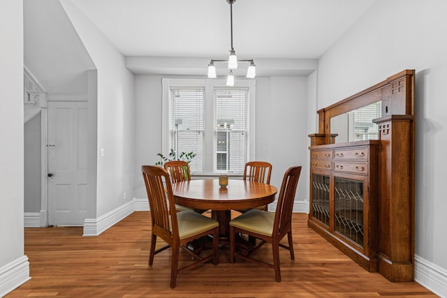 dining space with baseboards and wood finished floors