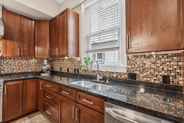 kitchen with a sink, brown cabinetry, dark stone counters, decorative backsplash, and stainless steel dishwasher
