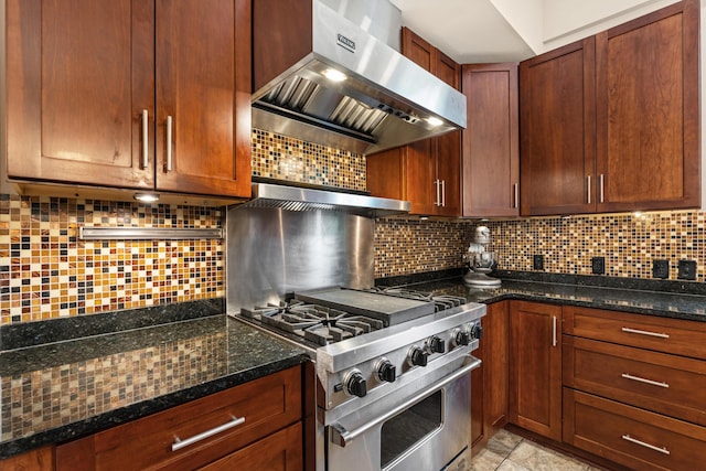 kitchen with dark stone counters, ventilation hood, stainless steel range, and tasteful backsplash