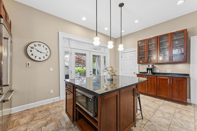 kitchen featuring glass insert cabinets, baseboards, a kitchen breakfast bar, french doors, and appliances with stainless steel finishes