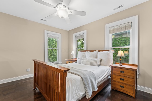 bedroom with baseboards, a ceiling fan, dark wood-style flooring, and visible vents