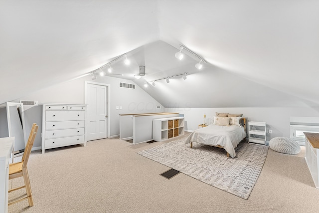 bedroom featuring track lighting, vaulted ceiling, carpet floors, and visible vents
