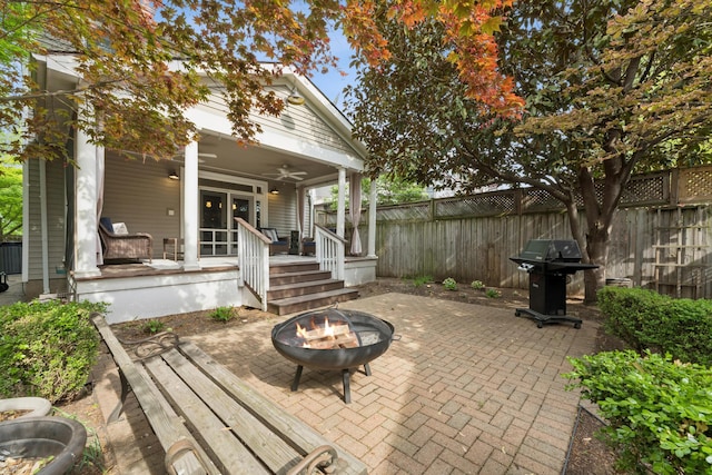 view of patio / terrace featuring a fire pit, grilling area, covered porch, a fenced backyard, and a ceiling fan