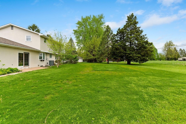 view of yard with central AC unit and a patio area