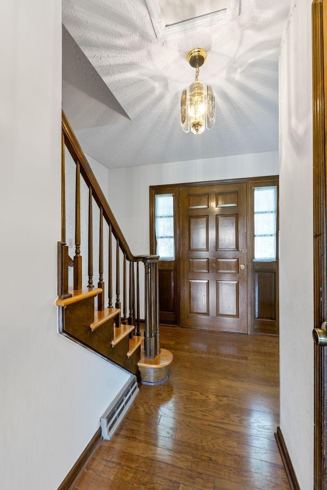 entrance foyer featuring an inviting chandelier, stairs, wood-type flooring, and visible vents
