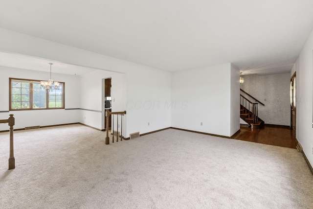 unfurnished living room featuring stairs, baseboards, visible vents, carpet flooring, and a notable chandelier