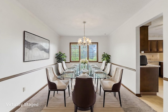 dining space with an inviting chandelier, light wood-style floors, and ornamental molding