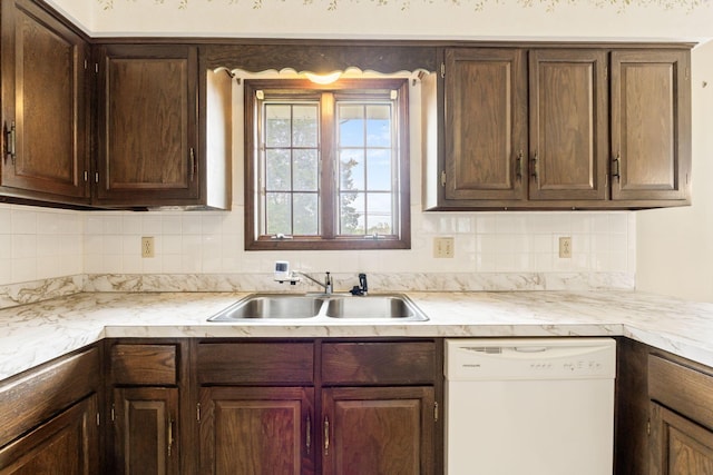 kitchen featuring light countertops, decorative backsplash, a sink, and dishwasher