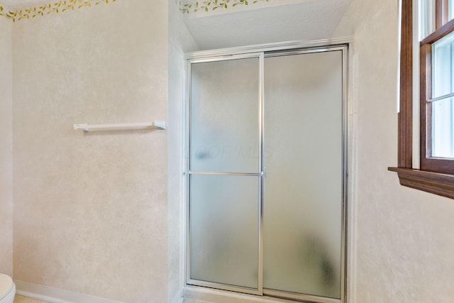 bathroom with an enclosed shower, baseboards, and toilet