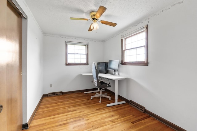 office area with ceiling fan, light wood finished floors, and visible vents