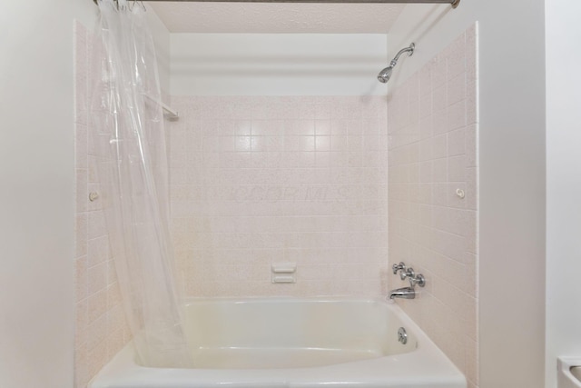 full bath with a textured ceiling and shower / bath combo