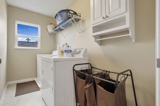 clothes washing area with cabinet space, baseboards, and washing machine and clothes dryer