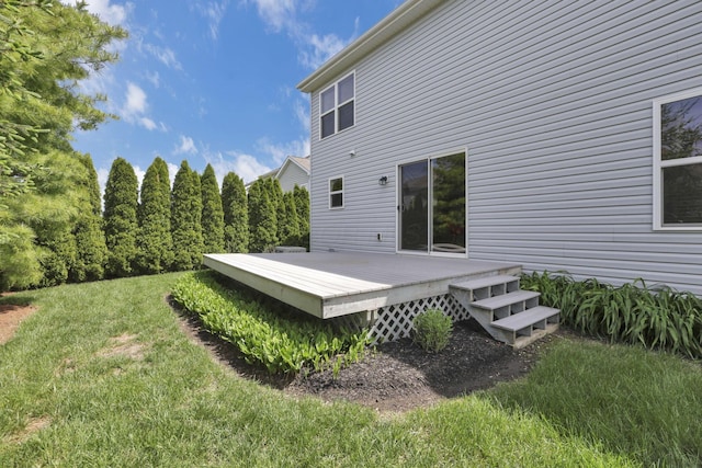 rear view of property featuring a lawn and a deck