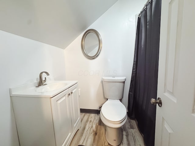 full bathroom featuring toilet, baseboards, wood finished floors, and vanity