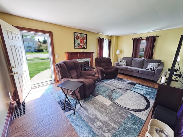 living room featuring a fireplace, wood finished floors, and visible vents