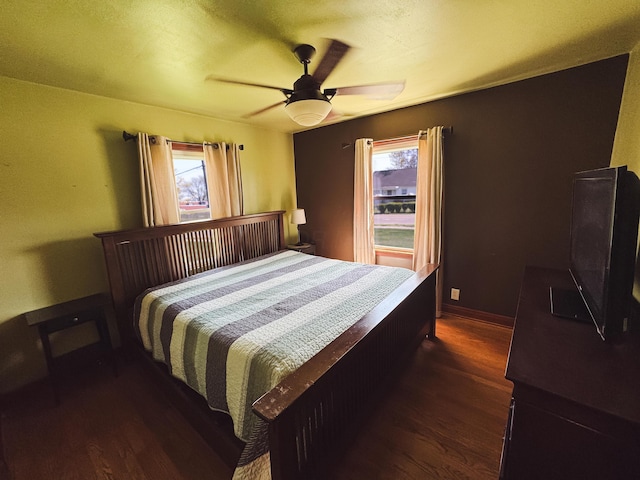 bedroom with a ceiling fan, multiple windows, and wood finished floors