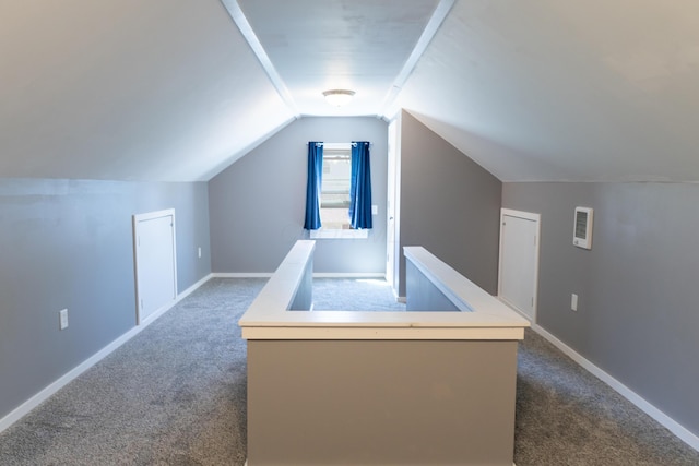 additional living space with carpet floors, baseboards, and vaulted ceiling