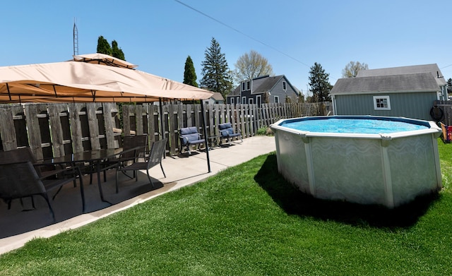 view of swimming pool with a lawn, fence, a fenced in pool, and a patio area