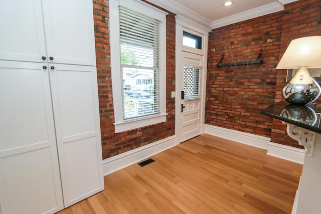 200 Thurman Ave, Columbus, OH 43206 - foyer with baseboards, visible vents, light wood-style flooring, and brick wall