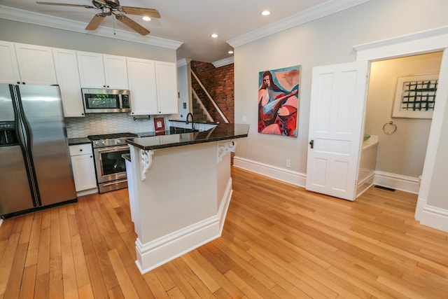 200 Thurman Ave, Columbus, OH 43206 - kitchen with a kitchen breakfast bar, ceiling fan, crown molding, appliances with stainless steel finishes, and white cabinetry