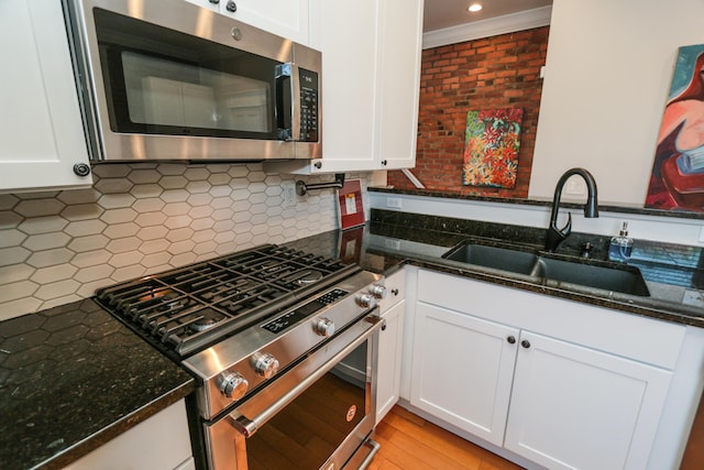 200 Thurman Ave, Columbus, OH 43206 - kitchen with white cabinets, appliances with stainless steel finishes, ornamental molding, and a sink