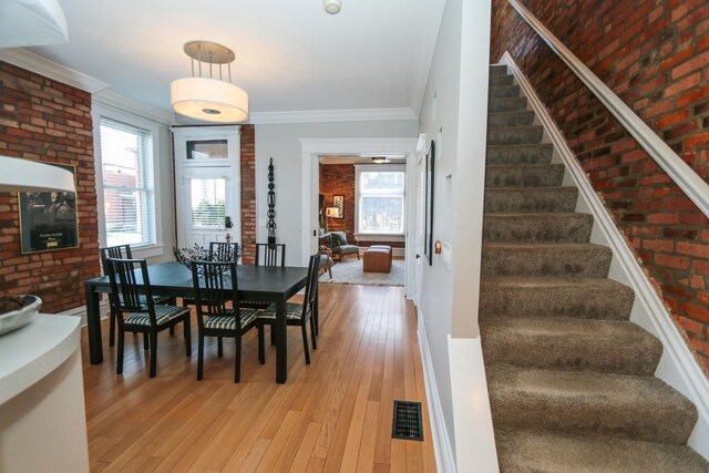 200 Thurman Ave, Columbus, OH 43206 - dining area featuring visible vents, brick wall, stairway, and light wood-type flooring