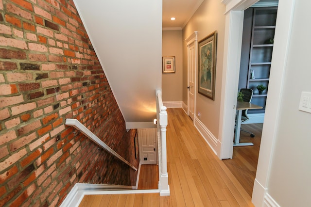 200 Thurman Ave, Columbus, OH 43206 - hall featuring baseboards, light wood-style flooring, brick wall, and an upstairs landing