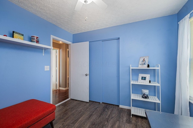 bedroom featuring a closet, wood finished floors, baseboards, a textured ceiling, and a ceiling fan
